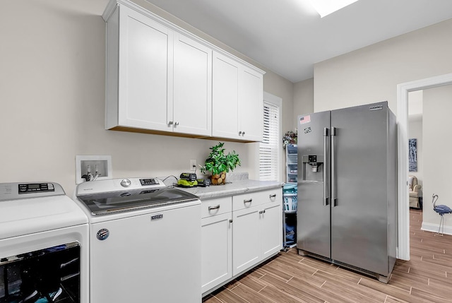 1033 Tuckers Rd, Pawleys Island, SC 29585 - washroom with baseboards, light wood finished floors, cabinet space, and washing machine and clothes dryer
