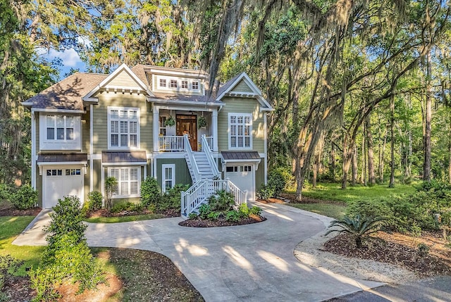 1033 Tuckers Rd, Pawleys Island, SC 29585 - craftsman-style home featuring covered porch, an attached garage, concrete driveway, and stairway