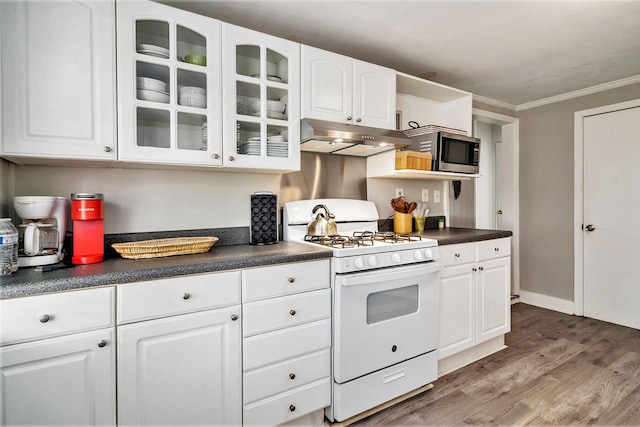504 W Ashley Ave, Folly Beach, SC 29439 - kitchen featuring white gas range oven, stainless steel microwave, under cabinet range hood, dark countertops, and ornamental molding