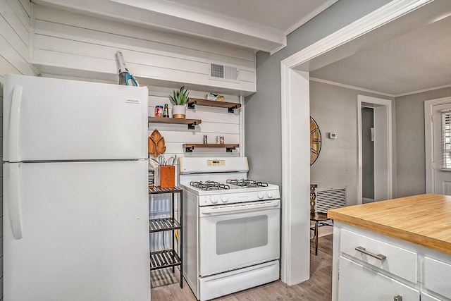 504 W Ashley Ave, Folly Beach, SC 29439 - kitchen with white appliances, light wood finished floors, ornamental molding, open shelves, and white cabinets