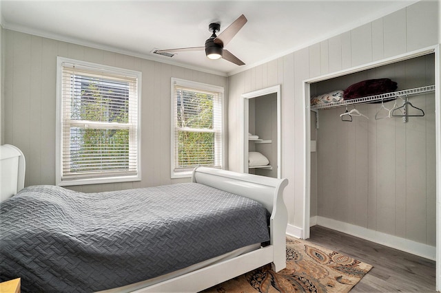 504 W Ashley Ave, Folly Beach, SC 29439 - bedroom with ornamental molding, wood finished floors, a ceiling fan, a closet, and wood walls