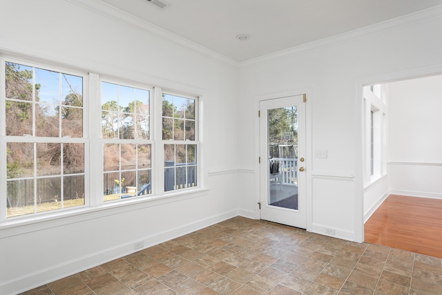 interior space with baseboards, stone finish floor, visible vents, and crown molding