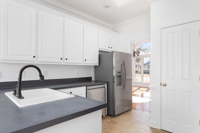 kitchen with stainless steel appliances, a sink, white cabinets, dark countertops, and crown molding