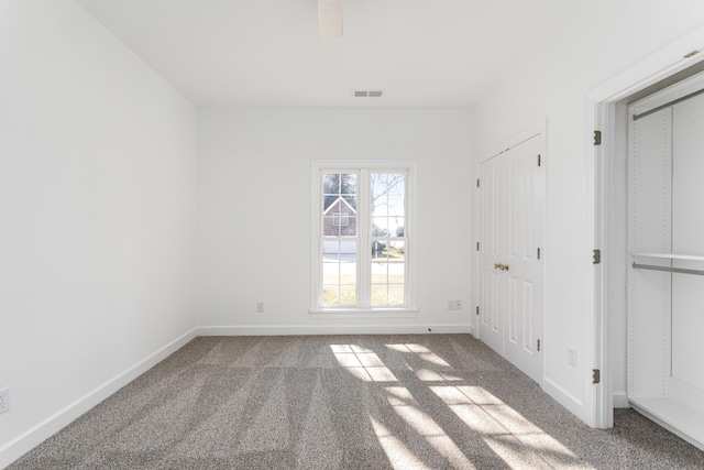 unfurnished bedroom with a ceiling fan, carpet, visible vents, and baseboards