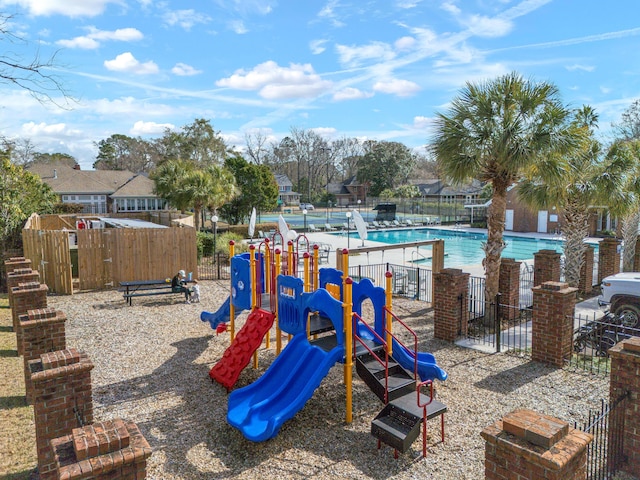 community playground featuring fence and a community pool