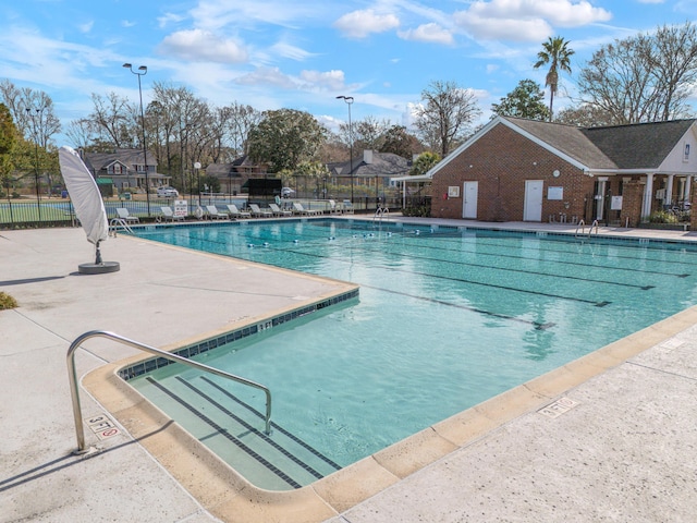 pool featuring fence and a patio