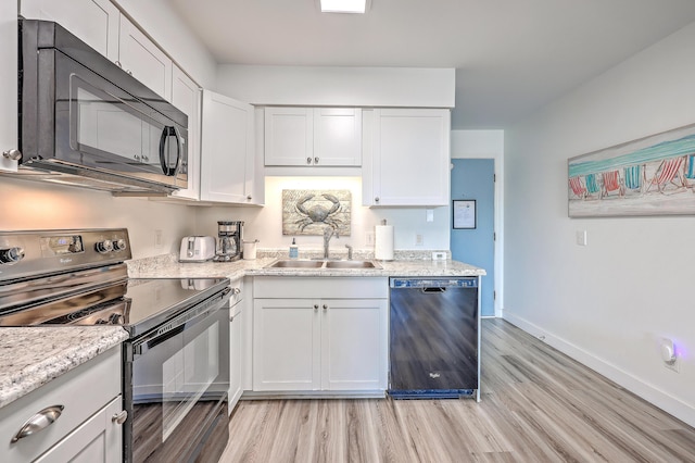 kitchen featuring light stone counters, sink, white cabinetry, and black appliances