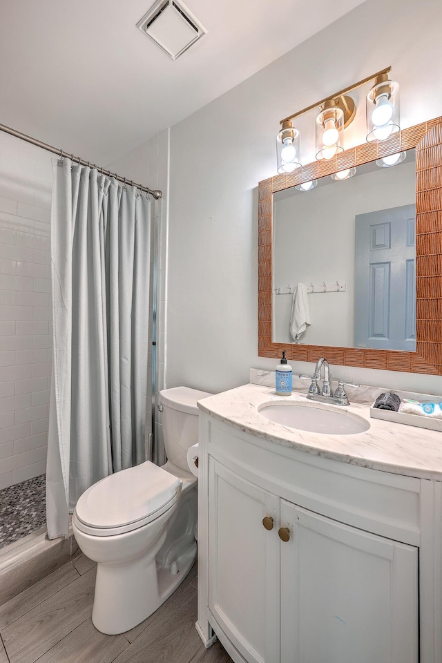 bathroom with curtained shower, hardwood / wood-style floors, toilet, and vanity