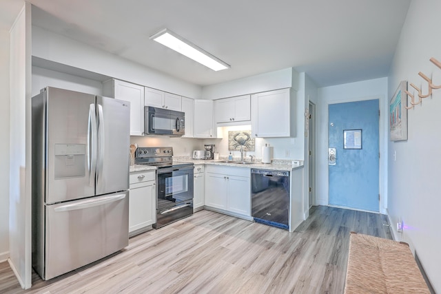 kitchen featuring black appliances, white cabinetry, sink, light stone counters, and light hardwood / wood-style flooring