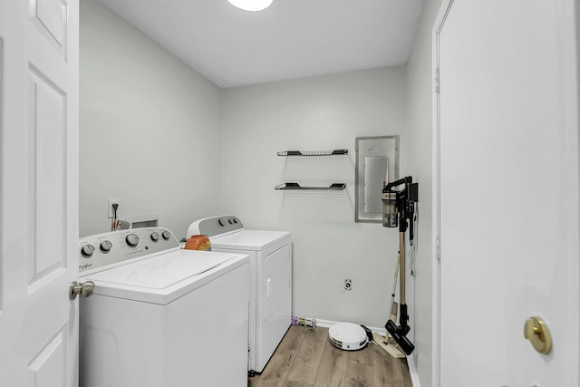 laundry area with laundry area, baseboards, washer and clothes dryer, and light wood finished floors