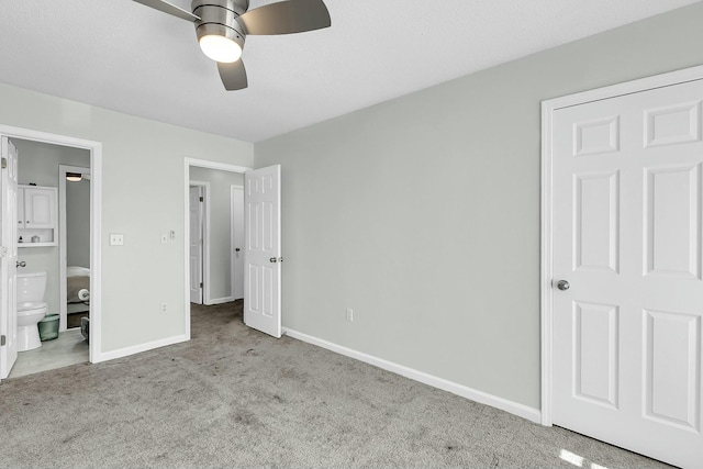 unfurnished bedroom with ensuite bathroom, ceiling fan, carpet, and baseboards