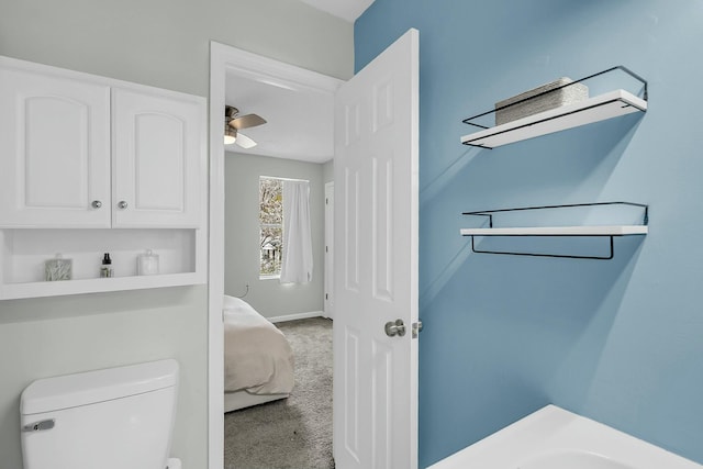 bathroom featuring toilet, ceiling fan, and baseboards