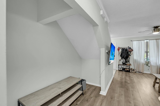 bonus room featuring lofted ceiling, ceiling fan, a textured ceiling, light wood-type flooring, and baseboards