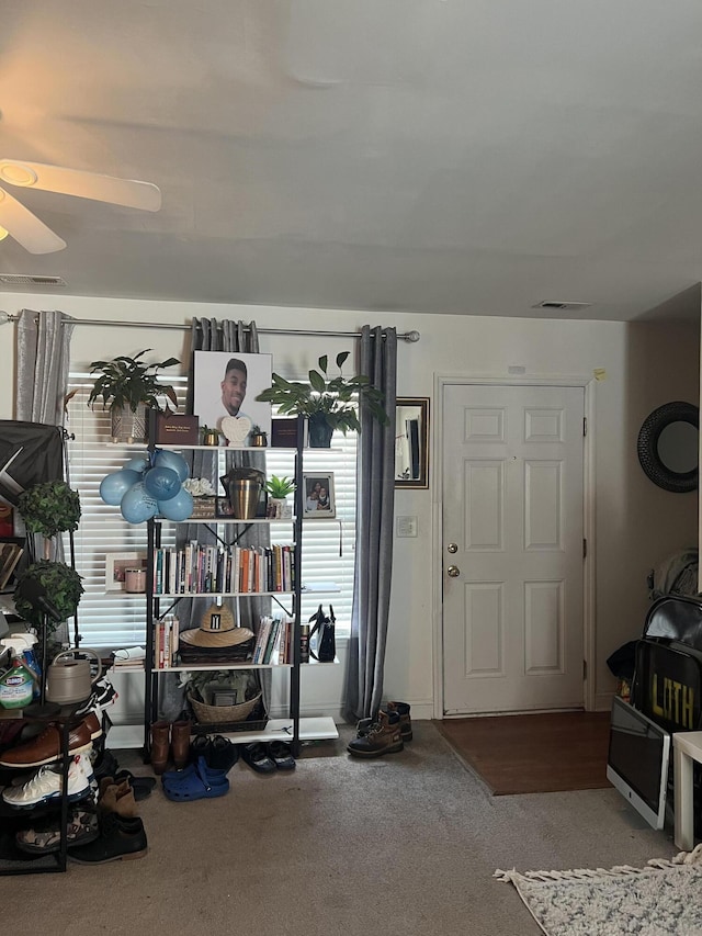 carpeted entrance foyer featuring ceiling fan