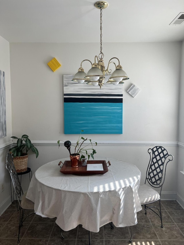 dining room with a notable chandelier and dark tile patterned floors