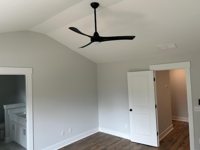 unfurnished bedroom with lofted ceiling, dark wood-style floors, and baseboards