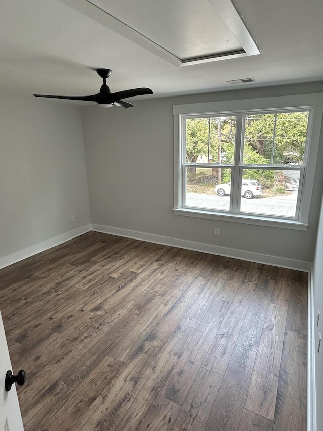 unfurnished room featuring a ceiling fan, visible vents, dark wood-style flooring, and baseboards