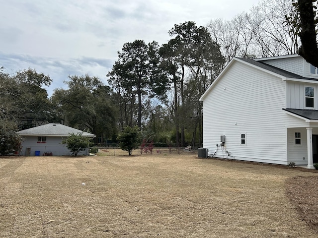 view of yard featuring central AC and fence