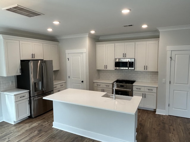 kitchen featuring visible vents, appliances with stainless steel finishes, dark wood finished floors, and white cabinets