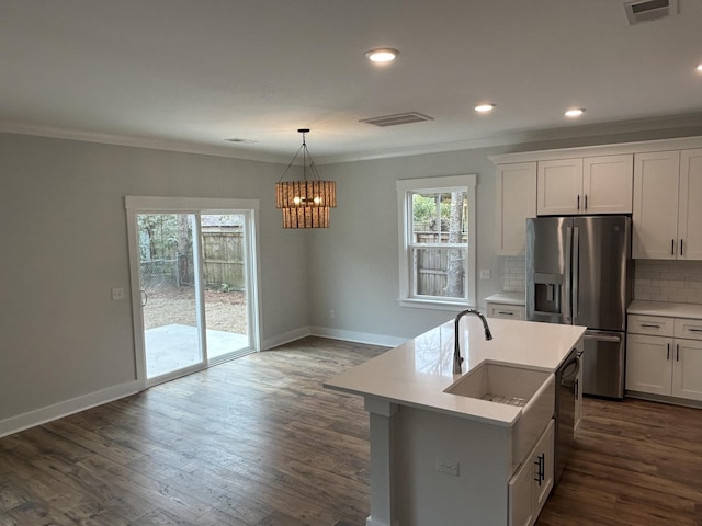 kitchen with tasteful backsplash, visible vents, ornamental molding, stainless steel refrigerator with ice dispenser, and a sink