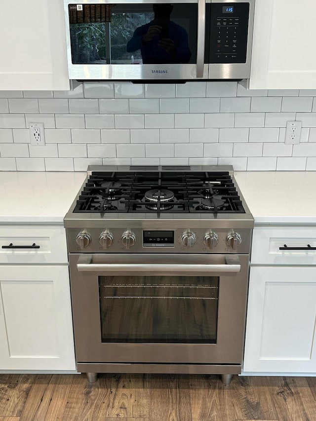 kitchen featuring light countertops, white cabinets, backsplash, and stainless steel appliances