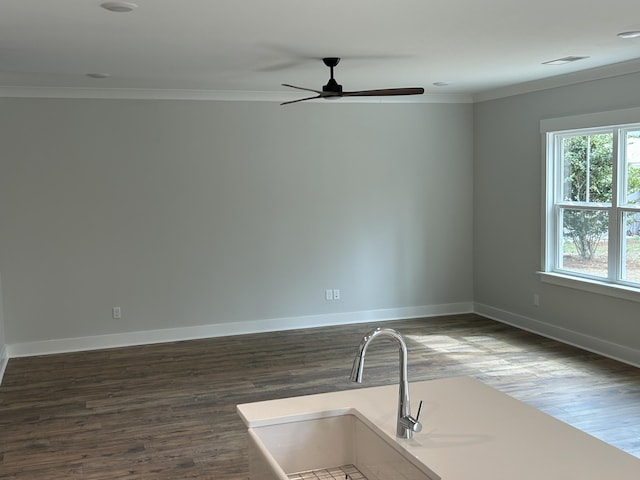 unfurnished room featuring a sink, dark wood-style flooring, and ornamental molding