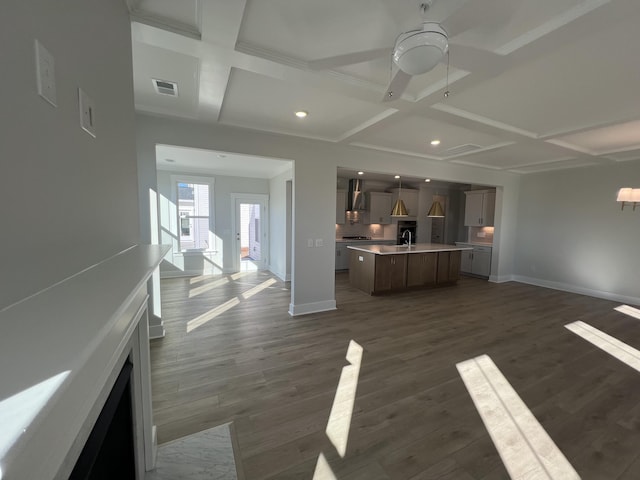 unfurnished living room featuring ceiling fan, dark hardwood / wood-style flooring, beam ceiling, and coffered ceiling