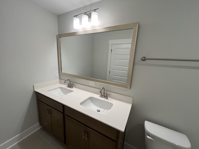 bathroom with toilet, vanity, and tile patterned floors