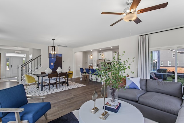 living room featuring plenty of natural light, ceiling fan with notable chandelier, and dark hardwood / wood-style floors