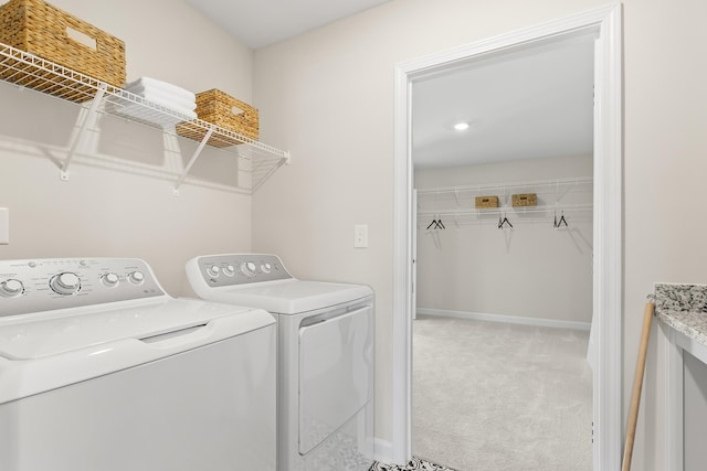 clothes washing area featuring light carpet and washing machine and clothes dryer