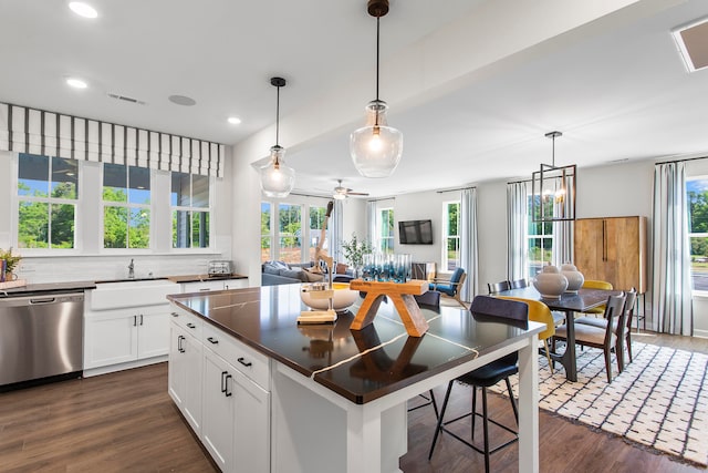 kitchen with decorative light fixtures, dark hardwood / wood-style flooring, dishwasher, white cabinets, and sink