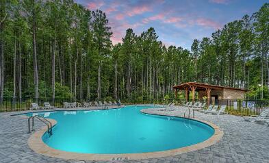 pool at dusk with a patio area