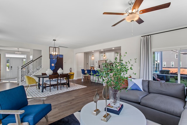 living room with ceiling fan with notable chandelier, dark hardwood / wood-style flooring, and a healthy amount of sunlight