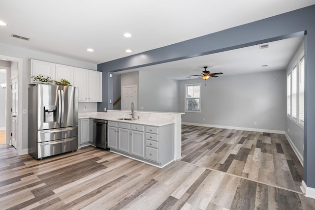 1070 Moss Grove Dr, Moncks Corner, SC 29461 - kitchen with appliances with stainless steel finishes, a peninsula, light wood-type flooring, light countertops, and recessed lighting