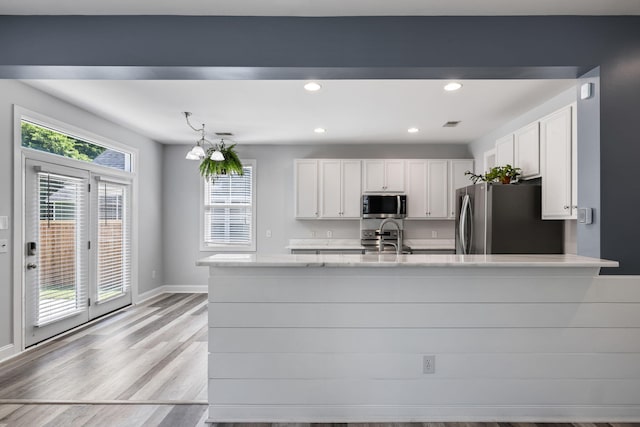 1070 Moss Grove Dr, Moncks Corner, SC 29461 - kitchen featuring appliances with stainless steel finishes, light countertops, white cabinets, recessed lighting, and light wood finished floors