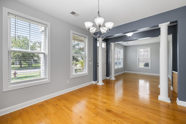 1070 Moss Grove Dr, Moncks Corner, SC 29461 - unfurnished dining area featuring ornate columns, a chandelier, and light wood-style flooring