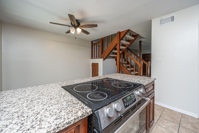 kitchen with light tile patterned floors, visible vents, stainless steel range with electric cooktop, ceiling fan, and baseboards