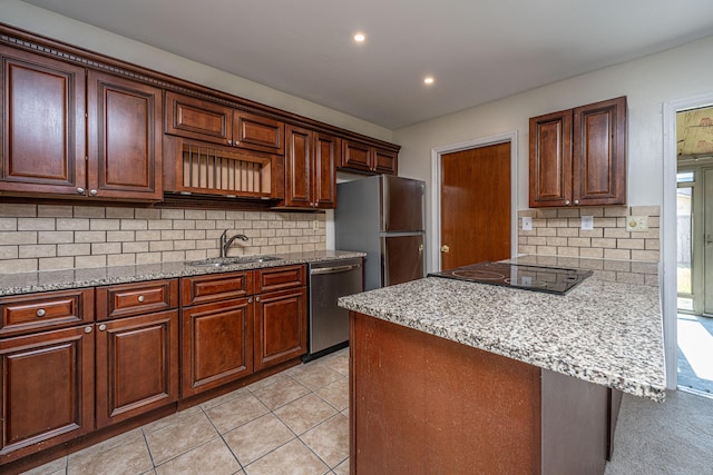 kitchen featuring light tile patterned floors, decorative backsplash, appliances with stainless steel finishes, light stone countertops, and a sink