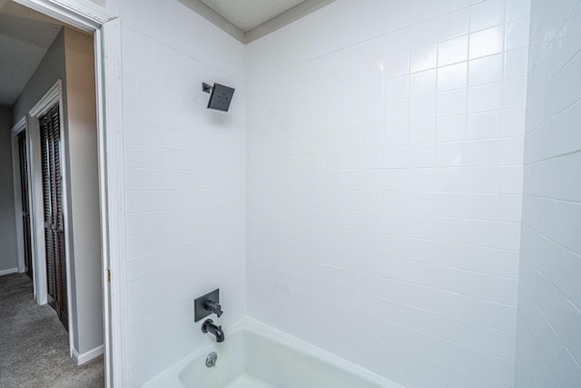 bathroom featuring baseboards and bathing tub / shower combination