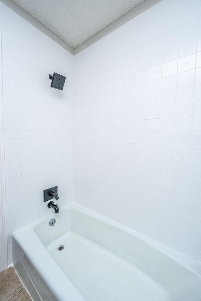 full bathroom with tile patterned flooring, tub / shower combination, and a textured ceiling