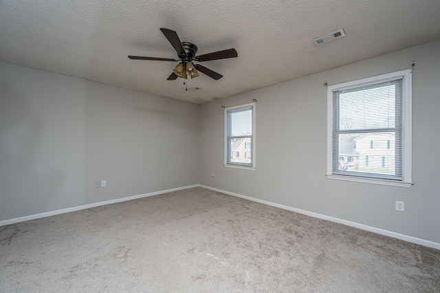 unfurnished room featuring a textured ceiling, carpet floors, visible vents, and baseboards