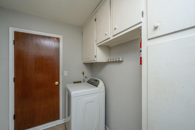 washroom with washer / dryer, cabinet space, and a textured ceiling