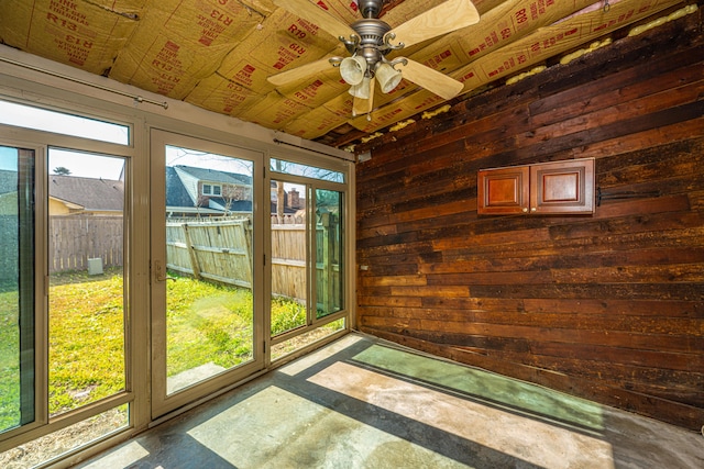 unfurnished sunroom with ceiling fan