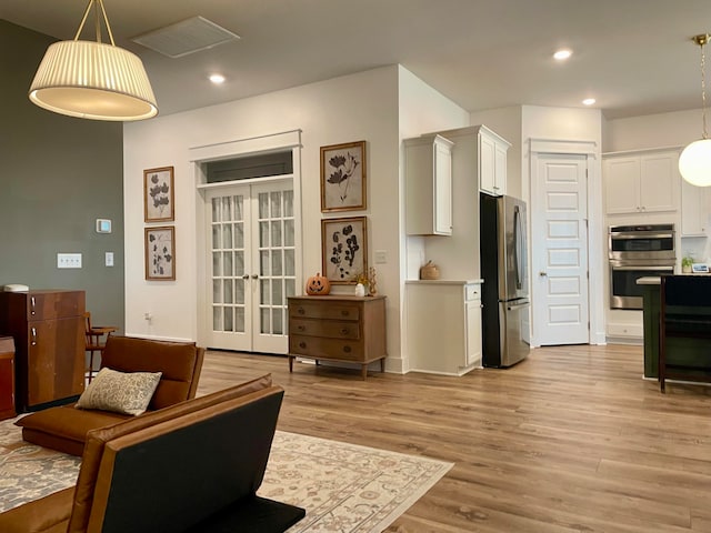 living room with light hardwood / wood-style floors and french doors