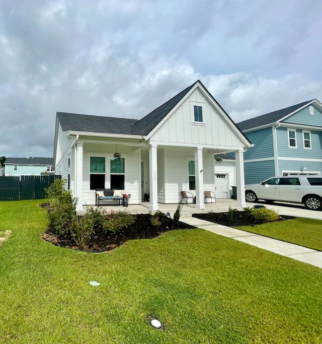 view of front of house featuring a front yard, a porch, and a garage