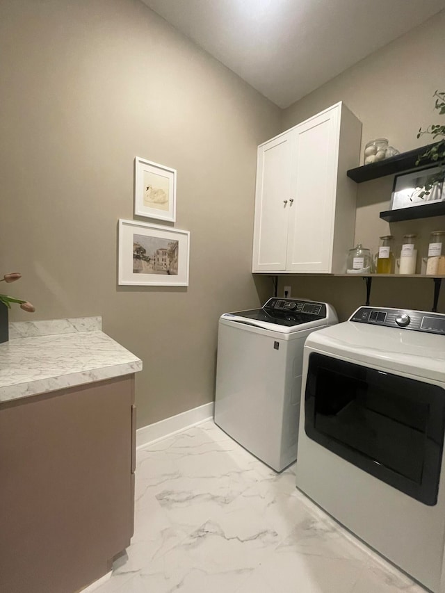 laundry area featuring washer and clothes dryer and cabinets