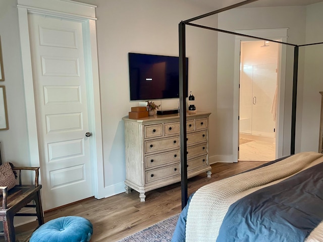 bedroom featuring light wood-type flooring and ensuite bathroom