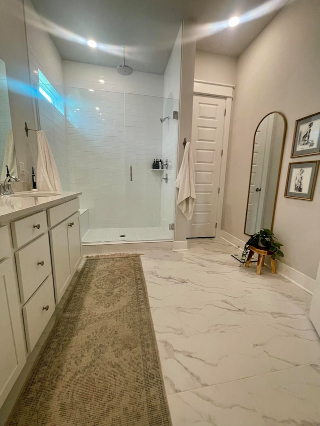 bathroom featuring a tile shower and vanity