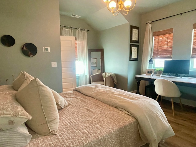 bedroom with vaulted ceiling, hardwood / wood-style floors, and a notable chandelier