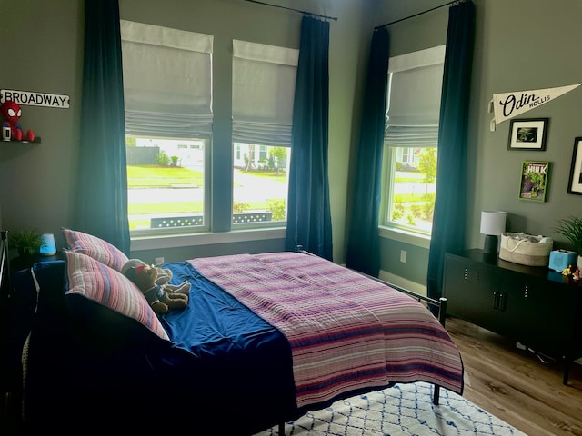 bedroom featuring multiple windows and hardwood / wood-style floors